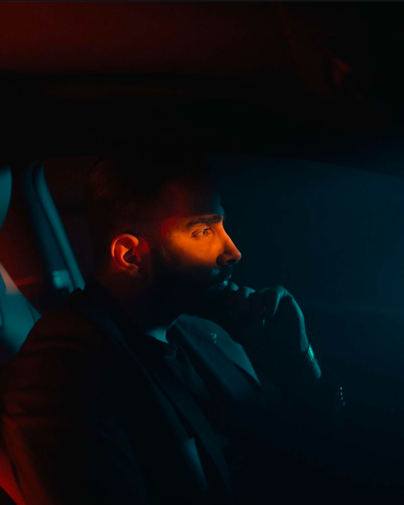 Portrait in a car with warm orange light and deep teal shadows
