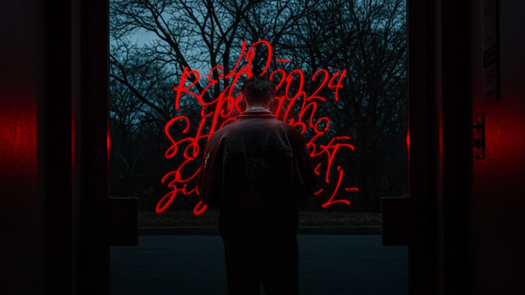 Showreel 2024 cover: a filmmaker facing red lettering and trees at dusk